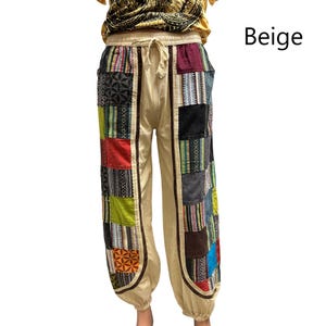 May include: Beige patchwork pants with a drawstring waist. The pants feature colorful, geometric patchwork panels down the sides. The word "Beige" is printed in the upper right corner.