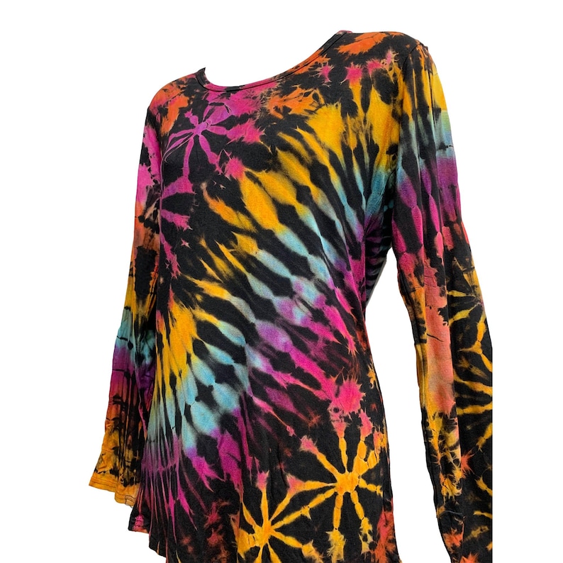 May include: A long-sleeved tie-dye shirt in a vibrant array of colors, including black, orange, yellow, pink, and blue. The shirt features a crew neck and a flowing, relaxed fit. The tie-dye pattern creates a unique, eye-catching design.