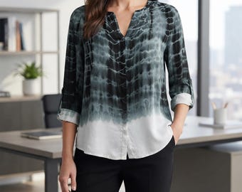 May include: A long-sleeve button-down blouse featuring a dark teal and black tie-dye pattern that transitions into a solid white hem. The shirt has a split V-neckline and sleeves that are rolled up to the elbows with a button tab detail.