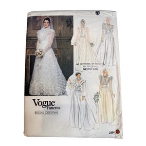 May include: A Vogue Patterns sewing pattern envelope for a bridal gown, number 2864. The front features a photograph of a white lace wedding dress with a high collar and long sleeves, alongside four illustrated variations of the gown design.