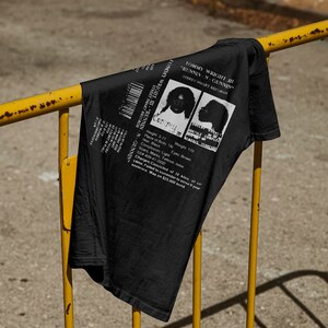 May include: Black t-shirt with a white graphic of a mugshot featuring the text "Tommy Wright III - "Runnin-N-Gunnin" Street Smart Records".
