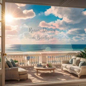 Puede incluir: Una vista desde un balcón con puertas francesas blancas abiertas a una escena de playa. El balcón tiene muebles de mimbre blanco y una barandilla blanca. La playa es arenosa con agua azul y un cielo azul brillante con nubes blancas. El sol brilla intensamente. El texto "Rococo Design & Boutique" es visible en la imagen.
