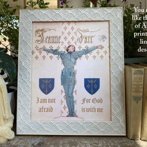 K&ouml;nnte beinhalten: Gerahmter Vintage-Druck von Jeanne d'Arc in R&uuml;stung, Arme ausgestreckt. Der Druck befindet sich in einem wei&szlig;en Rahmen mit einem strukturierten Muster. Der Text enth&auml;lt "Jeanne d'art", "Ich habe keine Angst" und "Denn Gott ist mit mir".
