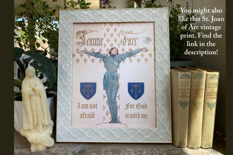K&ouml;nnte beinhalten: Gerahmter Vintage-Druck von Jeanne d'Arc in R&uuml;stung, Arme ausgestreckt. Der Druck befindet sich in einem wei&szlig;en Rahmen mit einem strukturierten Muster. Der Text enth&auml;lt "Jeanne d'art", "Ich habe keine Angst" und "Denn Gott ist mit mir".