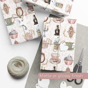 wrapping paper with whimsical vintage tea party illustrations including teacups, cupcakes, candlesticks, keys, and perfume bottles in pastel tones