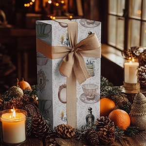 wrapping paper with whimsical vintage tea party illustrations including teacups, cupcakes, candlesticks, keys, and perfume bottles in pastel tones