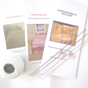 May include: A collection of miniature bedspread patterns and tools. The patterns include designs for double and single bedspreads, and a canopy and drapes. Also included is a spool of white thread and several long, thin needles.