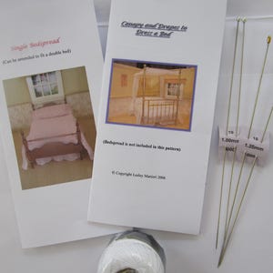 Pode incluir: Duas folhas de instruções intituladas "Single Bedspread" e "Canopy and Drapes to Dress a Bed" com imagens de camas em miniatura. Também, um carretel de linha branca e várias agulhas longas e finas com etiquetas de medição de plástico.
