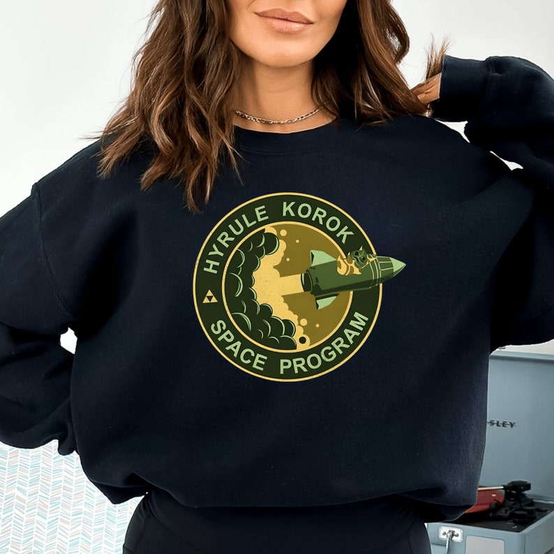 a woman wearing a black sweatshirt with a green logo on it
