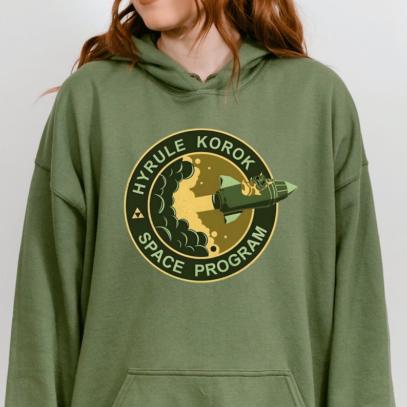 a woman wearing a green hoodie with a picture of a woman's face