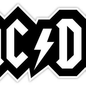 May include: A black and white sticker featuring the AC/DC logo. The design consists of bold, white block letters spelling AC/DC with a white lightning bolt symbol separating the two parts, all set against a thick black outline and white border.
