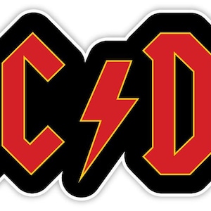 Op de afbeelding: Een sticker met het AC/DC-logo in vetgedrukte rode letters met een dunne gele omlijning. De letters staan tegen een effen zwarte achtergrond en een rood bliksemschichtsymbool scheidt de AC en DC, alles omrand door een witte rand.