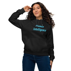 Può includere: Felpa con cappuccio nera con la scritta "Human Intelligence" in azzurro. La felpa ha una tasca frontale e un cappuccio con coulisse. La modella indossa jeans blu.