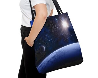 Op de afbeelding: Een zwarte tote bag met een blauw en zwart ruimtethema ontwerp. Het ontwerp bevat een planeet, sterren en een heldere zon.