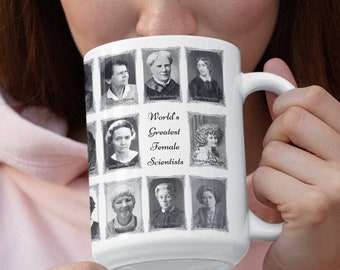 Puede incluir: Una taza de cerámica blanca con un collage de fotos en blanco y negro de científicas famosas. La taza tiene un asa y el texto "World's Greatest Female Scientists" está impreso en la parte delantera.
