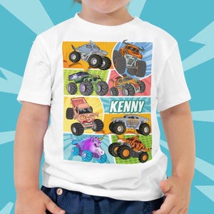 Könnte beinhalten: Weißes Kinder-T-Shirt mit einer farbenfrohen Grafik von Monstertrucks im Comic-Stil. Das Design umfasst verschiedene Monstertruck-Illustrationen und den Namen "Kenny". Der Hintergrund ist ein leuchtendes Blau.