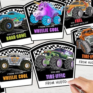 May include: A collection of illustrated monster truck cards with various designs. The cards feature phrases like "You are totally roar-some" and "I think you are wheelie cool." The trucks are in vibrant colors and have unique themes.