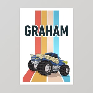 May include: A blue monster truck with the name "GRAHAM" printed above it. The truck is driving on a white background with colorful stripes behind it.