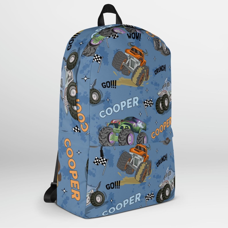 May include: Blue backpack with a monster truck pattern. The backpack features the name "COOPER" repeated throughout the design, along with phrases like "GO!" and "WOW!" The monster trucks are orange, green, and blue.