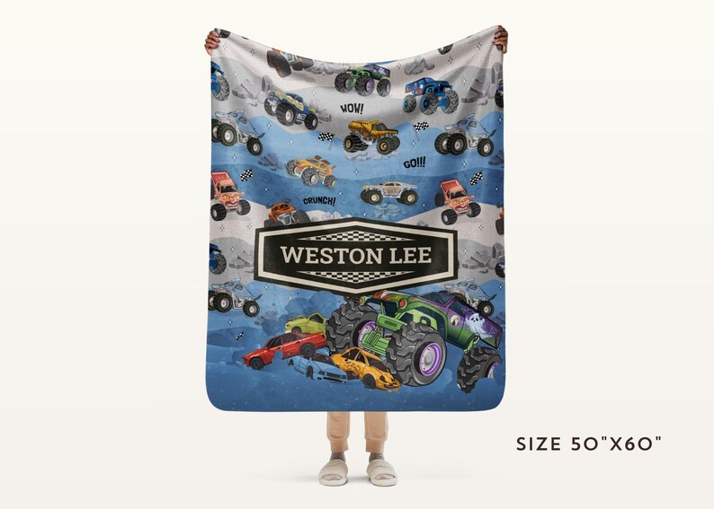 May include: A personalized blanket featuring a colorful monster truck design. The blanket has a blue and white background with various monster trucks and the name "WESTON LEE" in a black and white banner. The blanket measures 50" x 60".