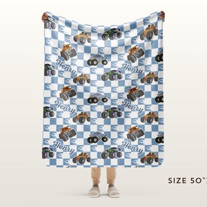 May include: A blue and white checked fleece blanket with a monster truck pattern. The trucks are orange, green, and blue. The blanket has the name "Henry" repeated throughout. The blanket is 50 inches by 60 inches.