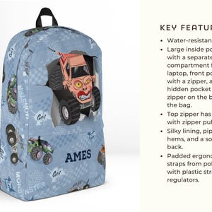 May include: Blue backpack with a monster truck design. The backpack features a large monster truck graphic bursting through the fabric. The bag has a top handle, black straps, and the name "AMES" printed on the side.