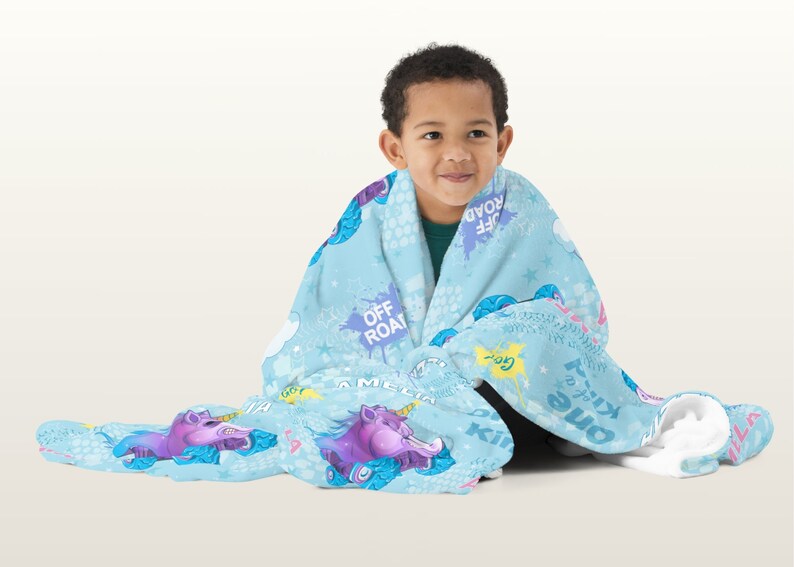 May include: A blue fleece blanket with a unicorn and off-road vehicle print. The blanket features the text "Off Road", "Go", "Kill 'em all", "One of a Kind", and "A Million Miles".