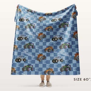 May include: A blue and white checkered fleece blanket with a repeating pattern of monster trucks and the name "Thomas". The blanket is 60 inches by 80 inches.