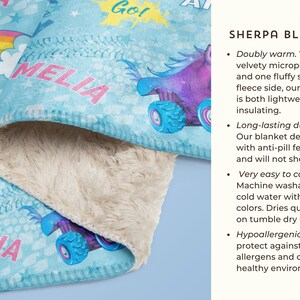 May include: A blue and white sherpa blanket featuring a colourful monster truck design and the text "MELIA" printed on it. The blanket is soft and fluffy, ideal for keeping warm on chilly evenings.