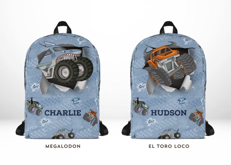 May include: Two blue backpacks with black straps. One features a shark-themed monster truck, the other an orange monster truck. Both have the names "Charlie" and "Hudson" printed on them, with the monster truck names "Megalodon" and "El Toro Loco".
