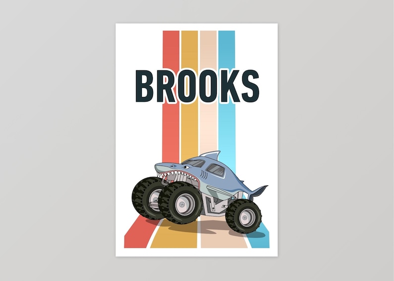 May include: A blue monster truck with a shark fin and teeth, with the name "BROOKS" in black text above it. The truck is on a background of colorful vertical stripes.