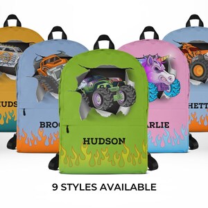 May include: Backpacks in various colors, each featuring a monster truck design bursting through a torn paper effect. The backpacks have flames at the bottom and personalized names. The text "9 STYLES AVAILABLE" is at the bottom.