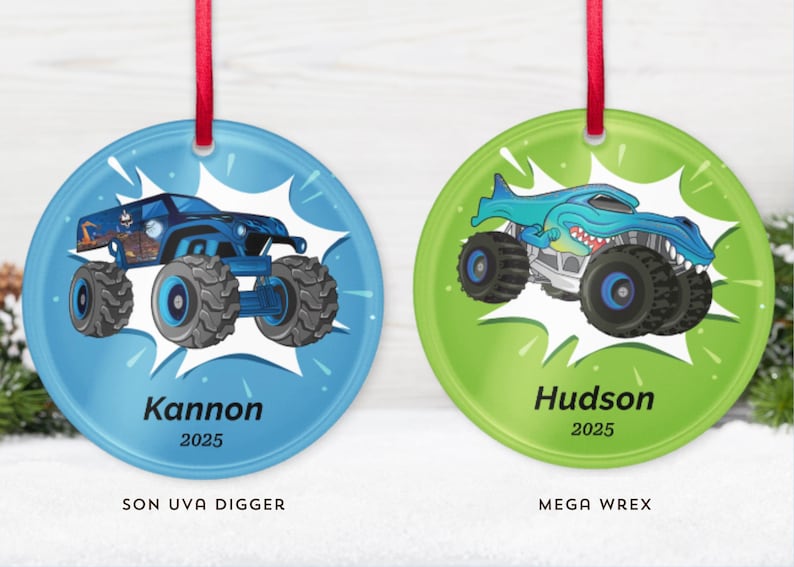 May include: Two round Christmas ornaments with red ribbon hangers. One is blue with a monster truck design and the name "Kannon" and the year "2025". The other is green with a shark-themed monster truck and the name "Hudson" and the year "2025".