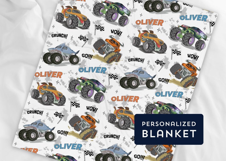 May include: A white personalised blanket featuring a repeating pattern of cartoon monster trucks in various colours, including blue, orange, and green. The trucks have different phrases on them, such as "Go!!!", "Wow!" and "Crunch!" The name "Oliver" is repeated throughout the blanket.