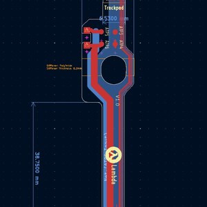 Op de afbeelding: Een schema van een printplaat met rode en blauwe paden, met tekstlabels zoals "Trackpad" en "Lambda". Afmetingen in millimeters: 15,1850 mm, 38,7500 mm en 6,5300 mm. De achtergrond is donkerblauw.