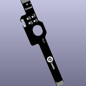 Op de afbeelding: Zwart printplaat met de tekst "P2 Trackpad", "ATP3 ATP4", "ATP5 ATP6", "V1.0" en het Lambda-logo. De printplaat heeft een unieke vorm met een gat en meerdere aansluitpunten.
