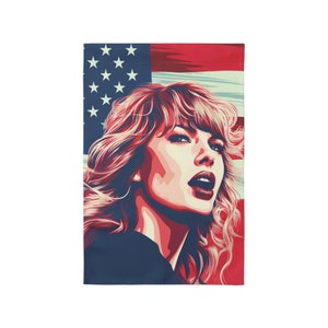May include: A rectangular face covering featuring a stylized portrait of a woman with red and blonde hair, set against a backdrop of the American flag in red, white, and blue. The portrait has a pop art style.