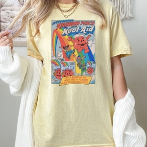 a woman wearing a yellow t - shirt with a cartoon character on it