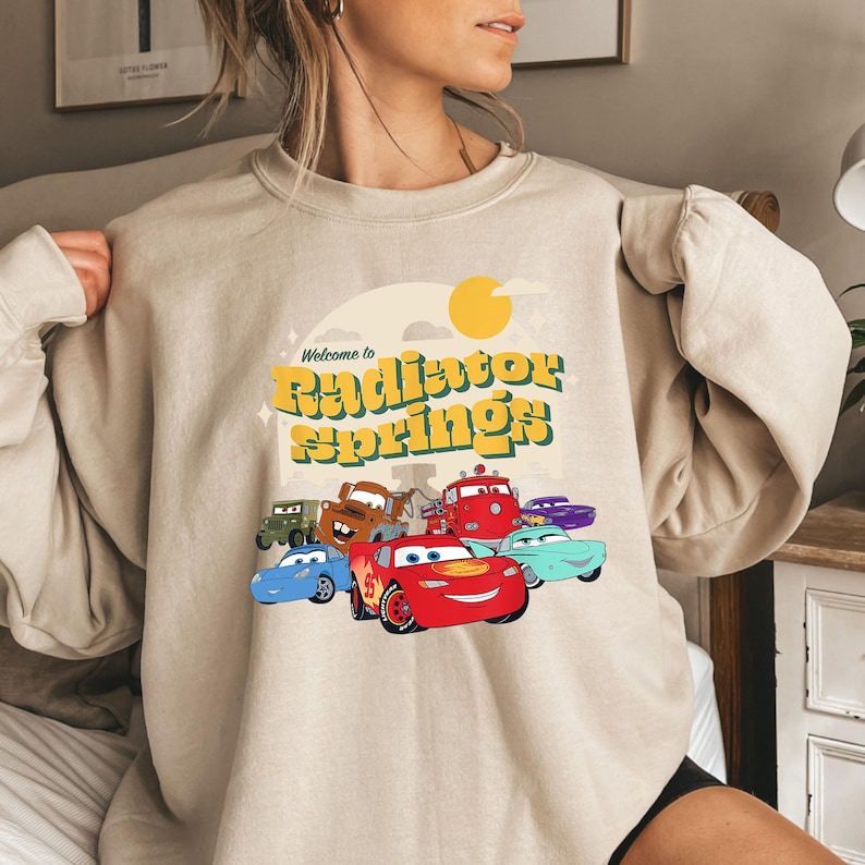 a woman wearing a sweatshirt with cars on it