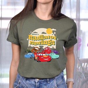 a woman wearing a green shirt with cars on it