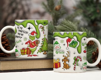 May include: Two white ceramic mugs with a Grinch design. One mug features the text "IS IT TOO LATE TO BE GOOD?" and a cartoon Grinch holding a coffee cup. The other mug has Grinch-related images.