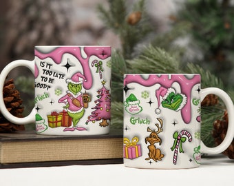 May include: Two white ceramic mugs with a pink and green Grinch Christmas design. The mugs feature the Grinch, a Christmas tree, presents, candy canes, and the text "Is it too late to be good?" and "Grinch".