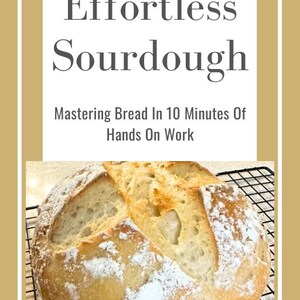 Puede incluir: Una hogaza de pan de masa madre recién horneada con una corteza dorada y una miga suave y aireada. El pan está sobre una rejilla. El texto "Effortless Sourdough" y "Mastering Bread In 10 Minutes Of Hands On Work" se muestra sobre el pan.