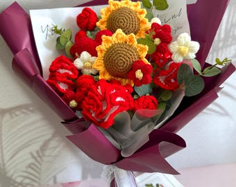 May include: A bouquet of handmade crochet flowers, including red roses, sunflowers, and white daisies, wrapped in purple paper. The bouquet is tied with a white ribbon and includes a handwritten note.