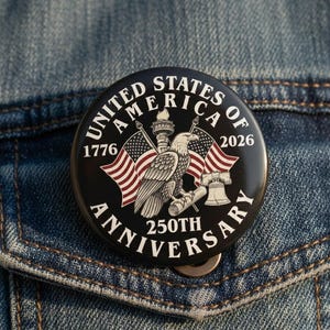 Puede incluir: Un botón redondo negro con el texto "UNITED STATES OF AMERICA 2026" y "250TH ANNIVERSARY". El botón presenta un águila, banderas, la Campana de la Libertad y los números "1776". El botón está prendido a una chaqueta vaquera.