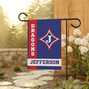 May include: A blue and red garden flag with the text "DRAGONS JEFFERSON" and a white diamond with a red outline and a white "J" inside.