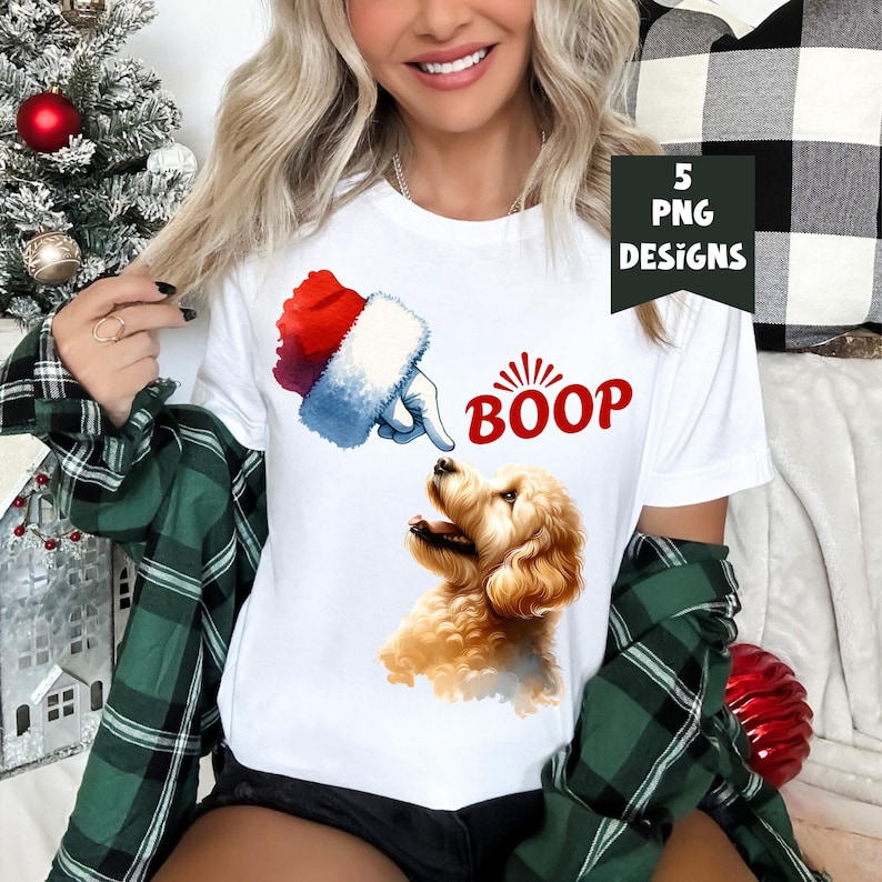 K&ouml;nnte beinhalten: Wei&szlig;es T-Shirt mit einer rot-wei&szlig;en Weihnachtsm&uuml;tze, die auf einen goldenen Pudel zeigt, mit dem Wort "BOOP" in roten Buchstaben.