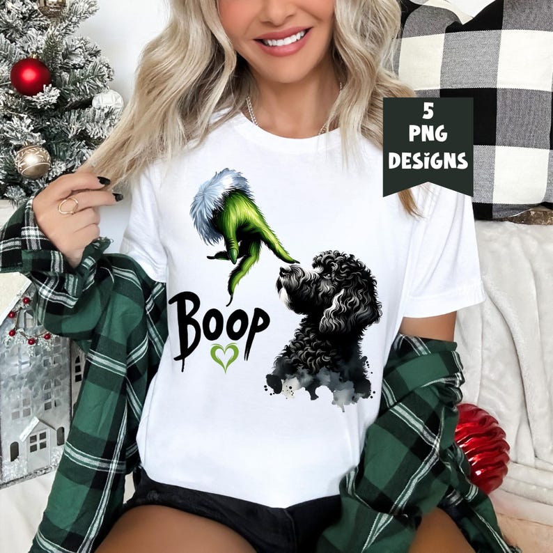 K&ouml;nnte beinhalten: Wei&szlig;es T-Shirt mit einer gr&uuml;nen Grinch-Hand, die sich nach einem schwarzen Hund ausstreckt, mit dem Wort "Boop" und einem gr&uuml;nen Herzen darunter.