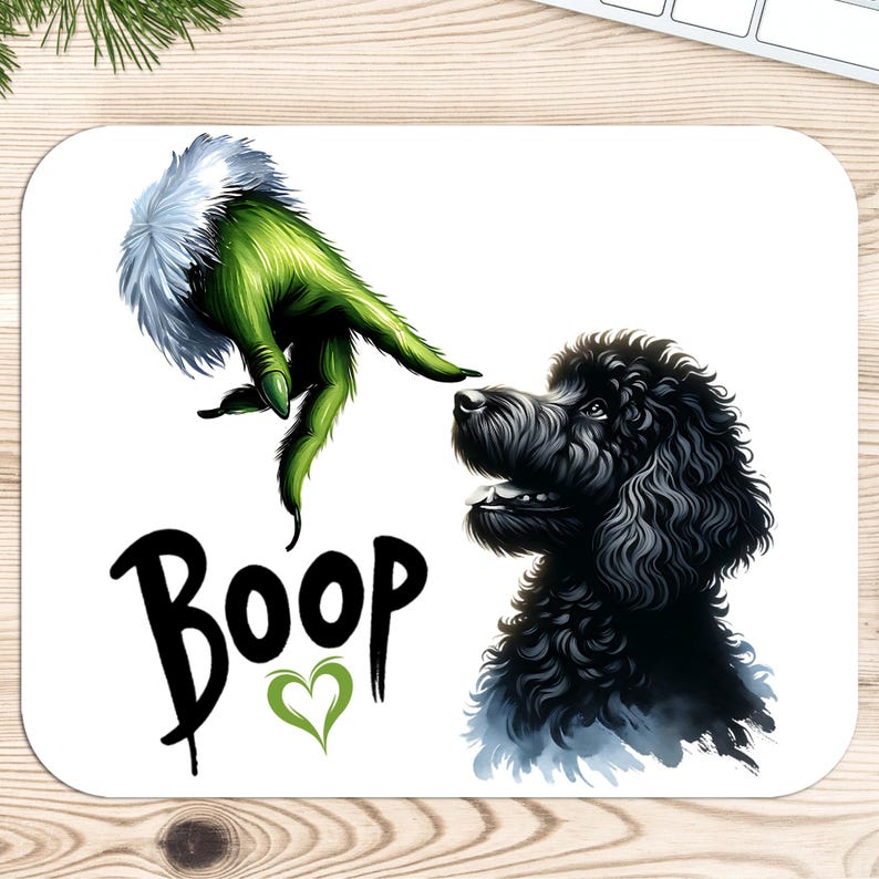 K&ouml;nnte beinhalten: Eine wei&szlig;e Mausmatte mit einer gr&uuml;nen Grinch-Hand, die sich nach einem schwarzen Pudel ausstreckt. Der Text "Boop" ist in Schwarz mit einem gr&uuml;nen Herzen darunter geschrieben.