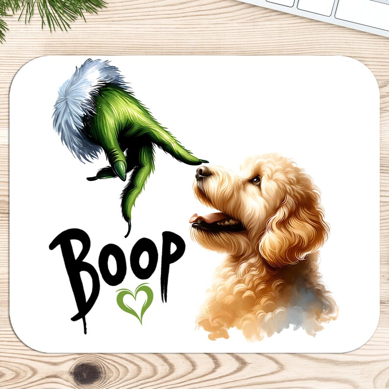 K&ouml;nnte beinhalten: Eine wei&szlig;e Mausmatte mit einer gr&uuml;nen Grinch-Hand, die sich nach einem Golden Retriever-Hund ausstreckt, um ihn zu "boop"en. Der Text "Boop" ist in Schwarz mit einem gr&uuml;nen Herzen geschrieben.